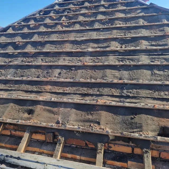 Stage one of a re-roof by Pro Roofing: the tiles are off, showing the old battens and perished roofing felt