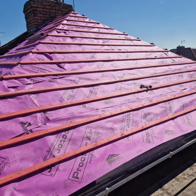 Stage three of the re-roof: a whole roof slope covered in new breathable membrane and evenly spaced battens